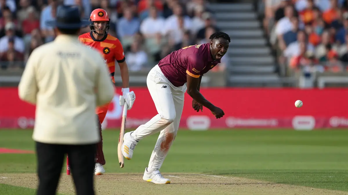 Cricket batter in mid-shot during a floodlit white-ball innings, captured from a tight sideline angle